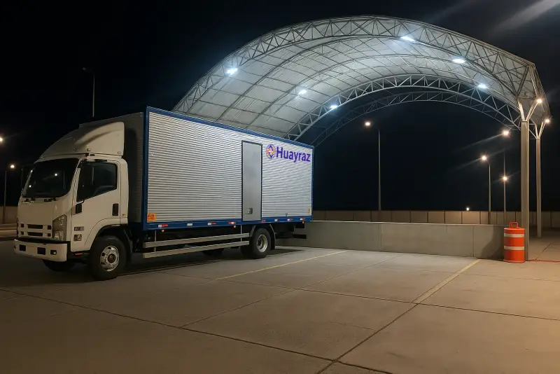 Camión de Huayraz cargando en un almacén de noche