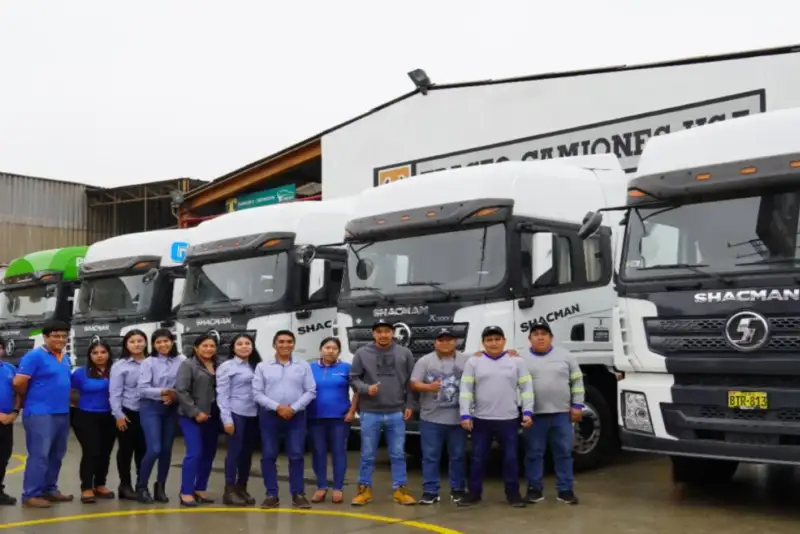 Colaboradores de Huayraz junto a camiones de la flota