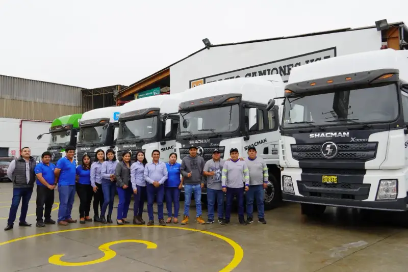 Equipo de Huayraz posando frente a la flota de tractos