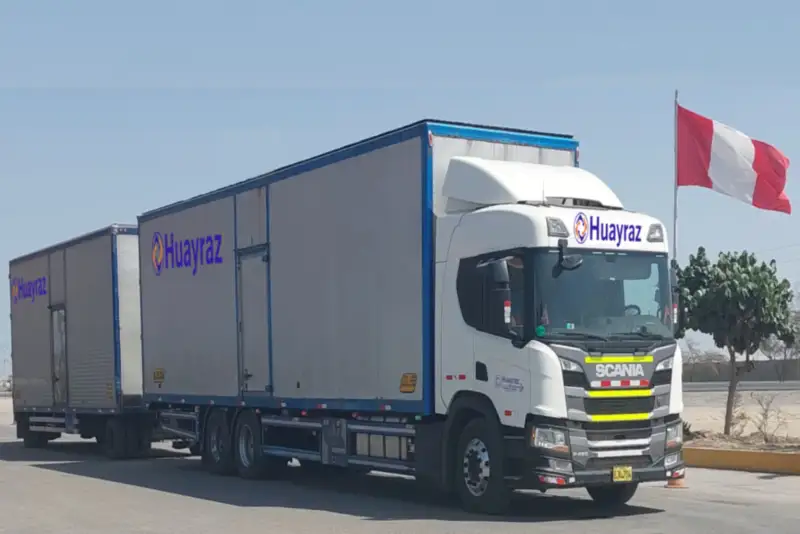 Tracto Scania de Huayraz con semirremolque estacionado junto a la bandera del Perú