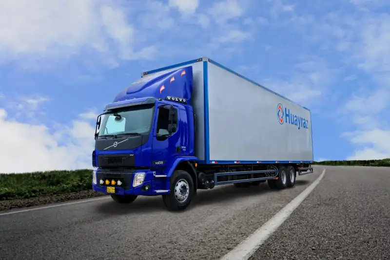 Camión Volvo azul con furgón de Huayraz en carretera