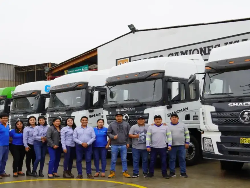 Colaboradores de Huayraz junto a camiones de la flota